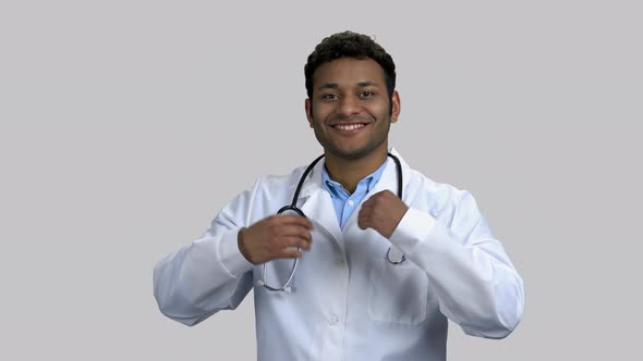 Young Darkskinned Male Doctor Puts on Stethoscope