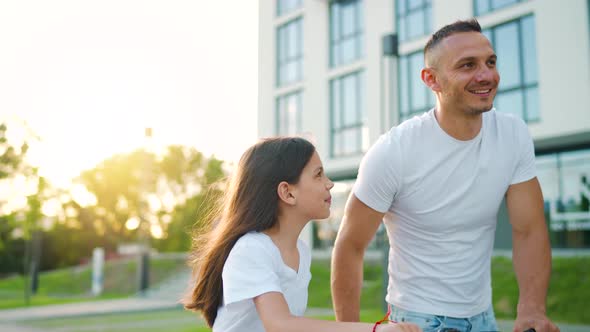 Dad and Daughter Walk Around Their Area After Cycling at Sunset