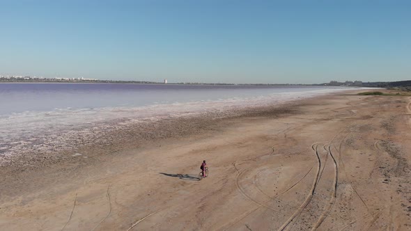 Woman rides bicycle along shore of Kuyalnik, Ukraine. Cycling concept. Gravel bike