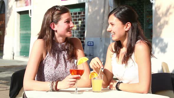 Two Young Women Cheering with Cold Drinks