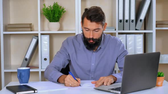 Young Businessman Sitting in Modern Office