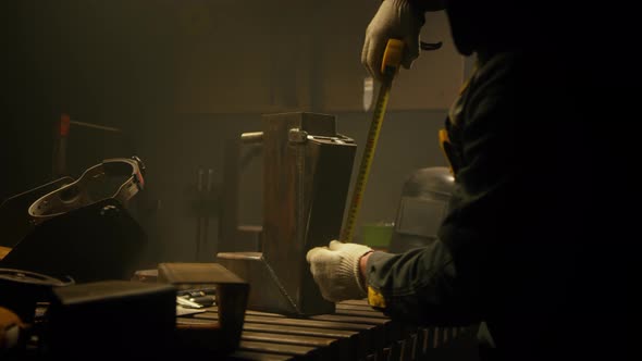 A skilled industrial worker checks a metal part