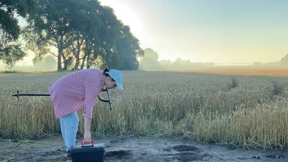 Female Agronomy Specialist Preparing to Examine Soil at Sunrise