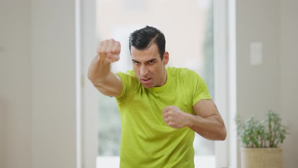 Portrait of Concentrated Handsome Sportsman Changing Boxing Positions Looking at Camera