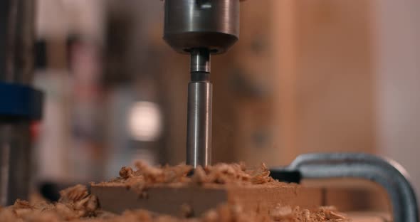 Woodworker Drills Holes in Wooden Plank with Drilling Machine in Slow Motion Carpentry at Workshop