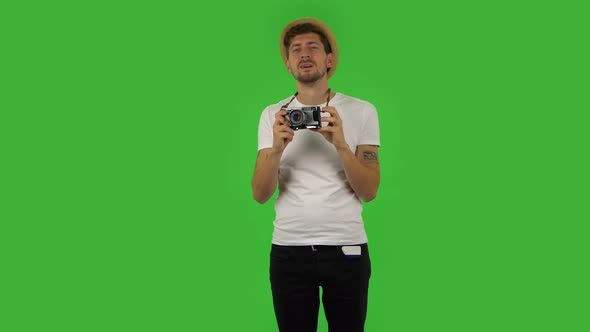 Tourist in Hat on Vacation Takes Pictures on a Retro Camera. Green Screen