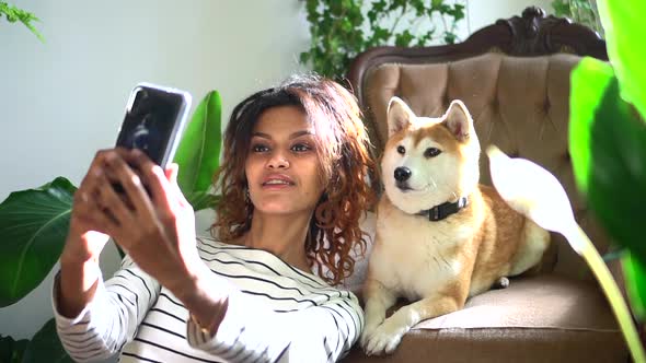 Happy Woman Taking Selfie Photo with Dog Sitting at Home Room Spbd