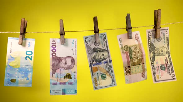 Banknotes of Different Countries Dry on a Clothespin Rope