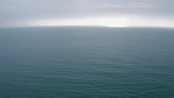 Aerial still view of the Pacific Ocean late in the afternoon