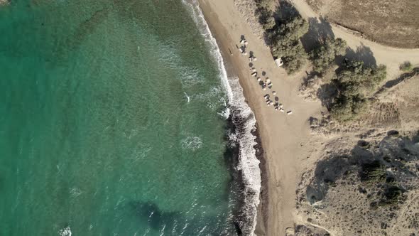 People relax as turquoise blue waves gently roll onto sandy beach on the Mediterranean. Summertime M