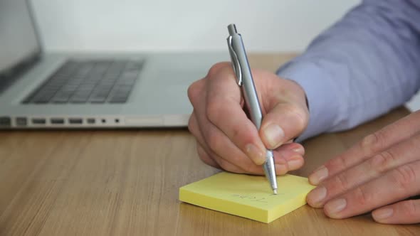 MS, Male writing note and typing on laptop