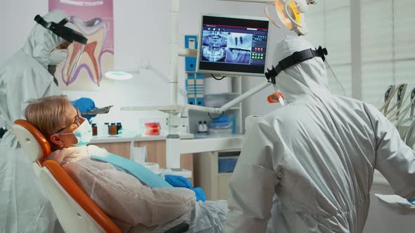 Orthodontist in Protective Suit Lighting the Lamp Until Examination