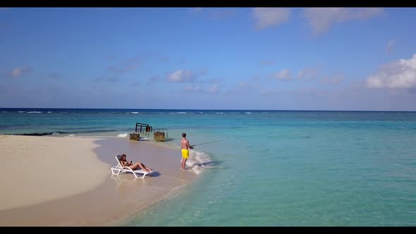 Man and woman happy together on beautiful island beach wildlife by blue green ocean with clean sand 