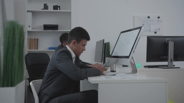 Two Men Sit at a Table at the Office.