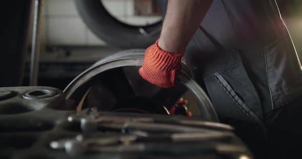 Male Hands Fixing an Alloy Wheel on Tyre Changer Machine on Auto Service