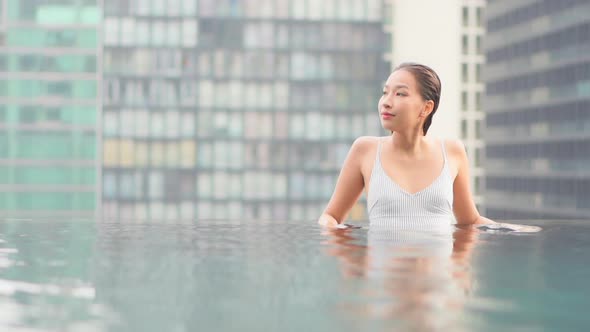 Young asian woman enjoy around outdoor swimming pool for leisure