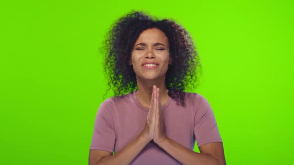 African American woman crosses fingers anticipate hearing good news