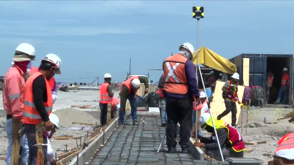 zoom out while a lot of workers are busy in the middle of a big construction