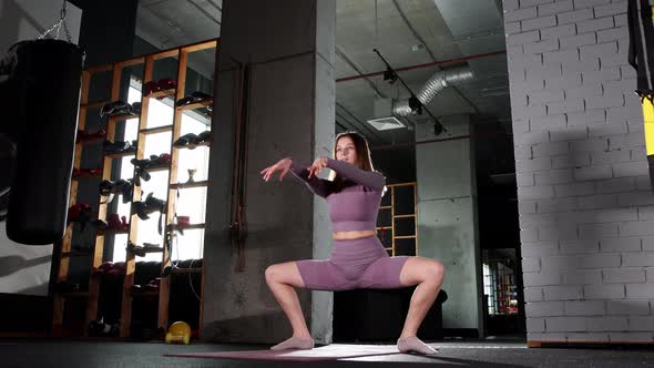 Young Woman Doing Pilates Exercises  Squatting