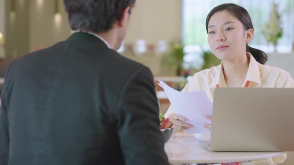 asian businessman and woman discuss together with laptop in modern office design