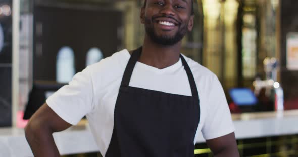 Portrait of african american barista smiling to camera wearing apron in cafe