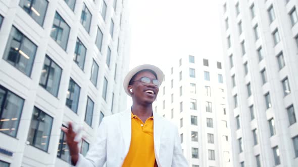 Smiling guy listens to music in wireless headphones