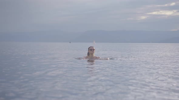 Attractive young girl swimming in a mountain lake