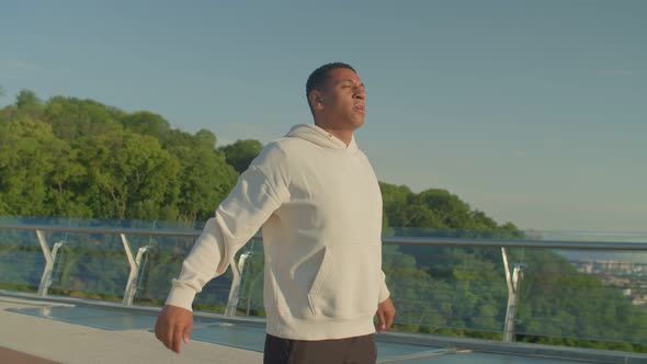 Determined Fit Black Male Athlete Practicing Shoulder Stretch Before Jogging