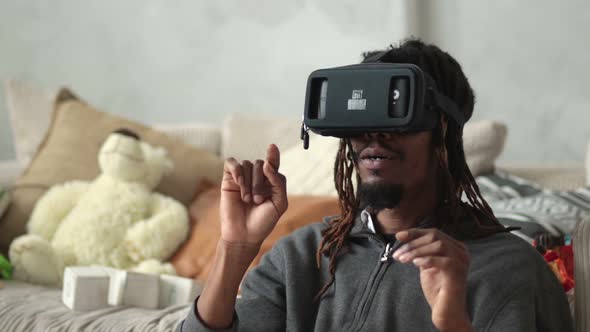 Excited Man Using Virtual Reality Goggles at Home