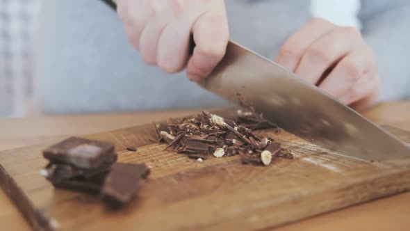 Slow motion shot of pregnant woman cutting chocolate with nuts