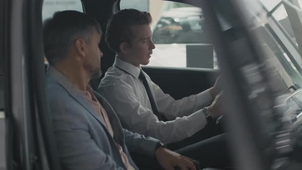 Dealership Salesman Showing Interior of Car to Customer