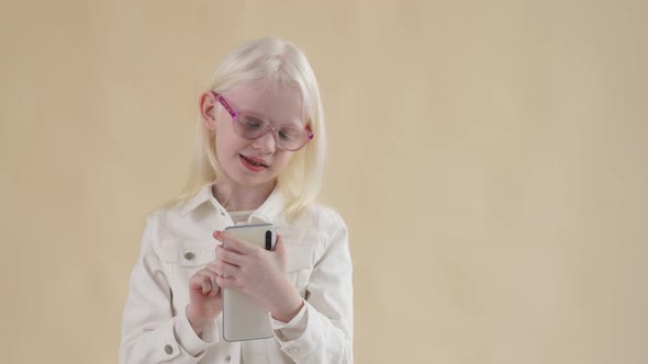Adorable Little Albino Girl Watching Videos on Smartphone