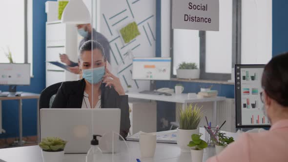 Woman with Protective Face Mask Working on Laptop Computer in Company Office