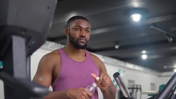 African American Man Drinking Water After Training in the Gym