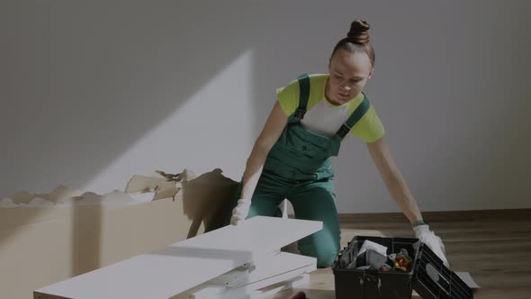 Young Female is Assembling a Piece of Furniture