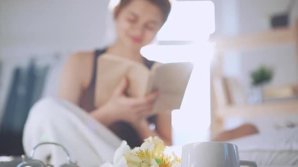 Caucasian Lady Reading Book Sitting in Bed in Slowmotion