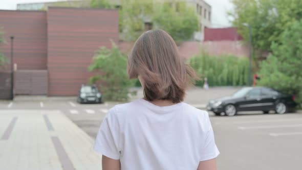 Back View of Woman Walking on Street