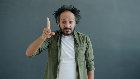 Slow Motion Portrait of Mixed Race Guy Knocking on Head Warning of Stupid Decisions