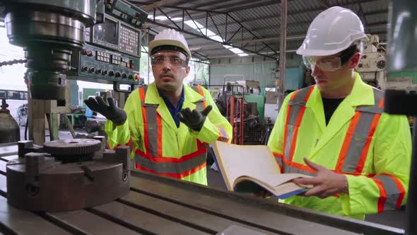 Group of Factory Workers Using Machine Equipment in Factory Workshop