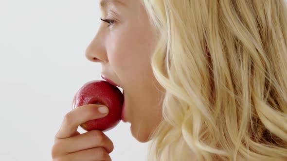 Close-up of beautiful woman eating red apple