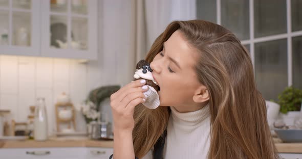 Young Beautiful Lady Biting Cupcake Enjoying Glutenfree Homemade Pastry at Kitchen Slow Motion