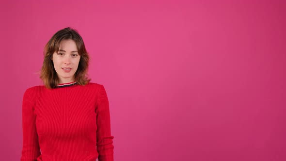 Young Woman Making a Thumb Up Gesture on a Pink Background