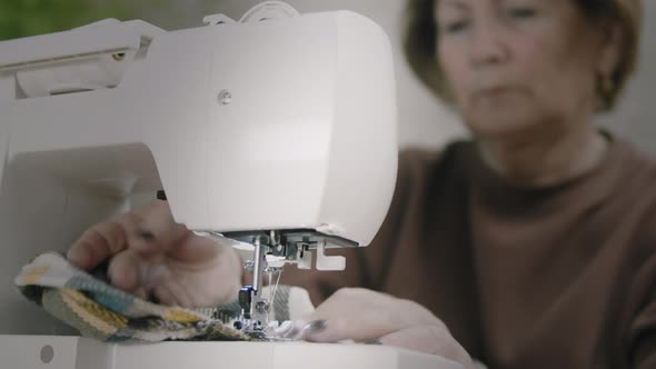 Senior Woman Sewing At Home