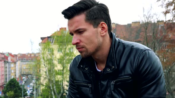 Young Handsome Sad Man Sits on Bench and Thinks in Park - Detail of Face Expression