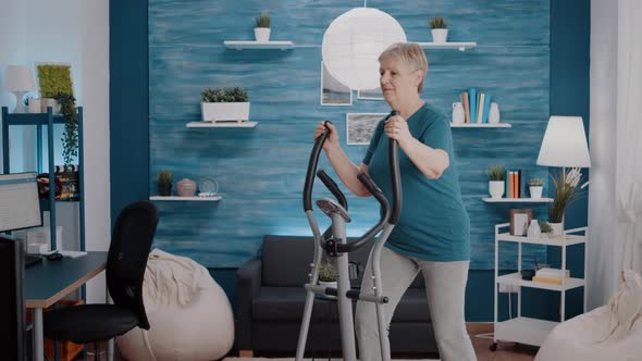 Pensioner Doing Physical Exercise with Cardio Machine