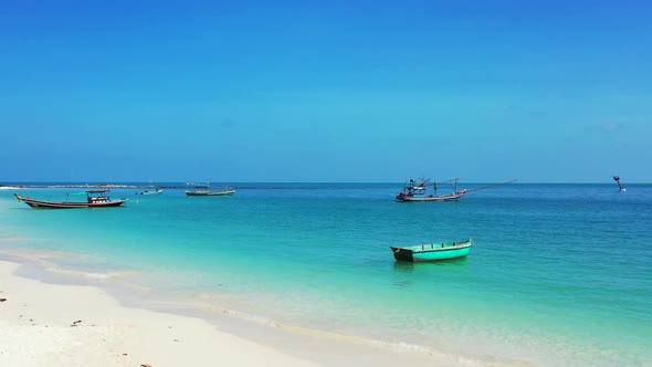 Daytime overhead copy space shot of a white paradise beach and aqua blue water background 