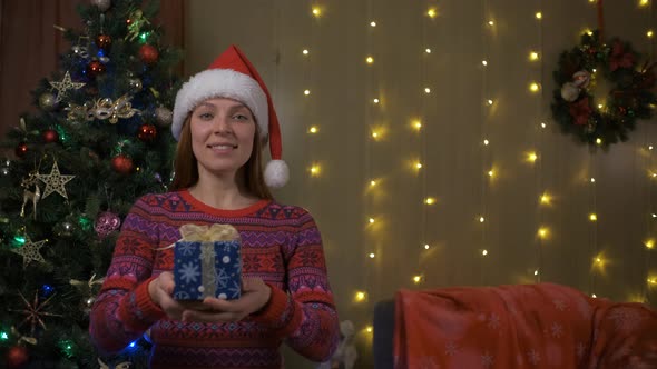 Young Woman with Santa Hat Giving a Present Gift Certificate