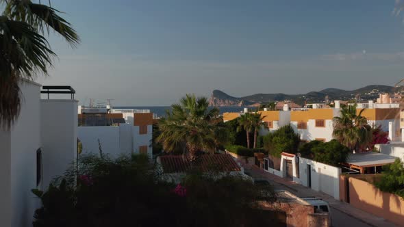 Establisher Shot of Beautiful White Villa Houses with Cars Parked on Empty Street Outside Gate at