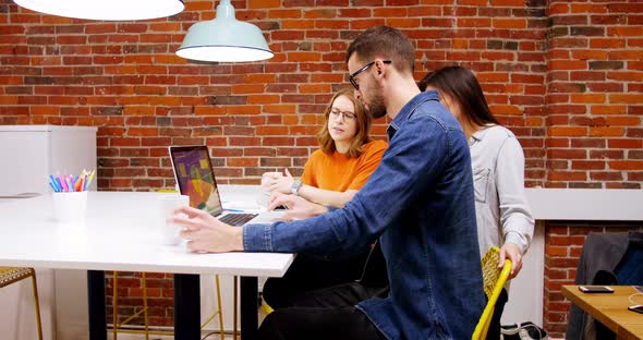 Group of executives discussing over laptop in the conference room