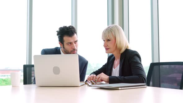 Two Business People Talk Project Strategy at Office